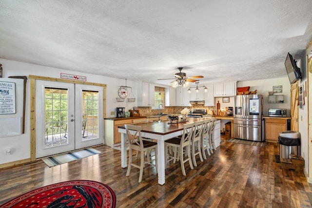 dining room featuring sink, dark hardwood / wood-style flooring, a textured ceiling, and french doors