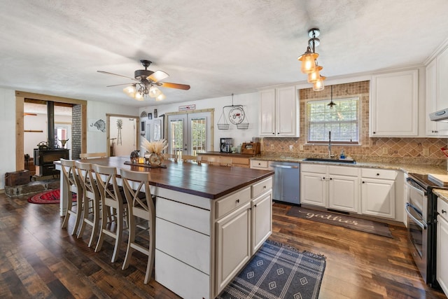 kitchen featuring white cabinetry, hanging light fixtures, sink, french doors, and stainless steel appliances