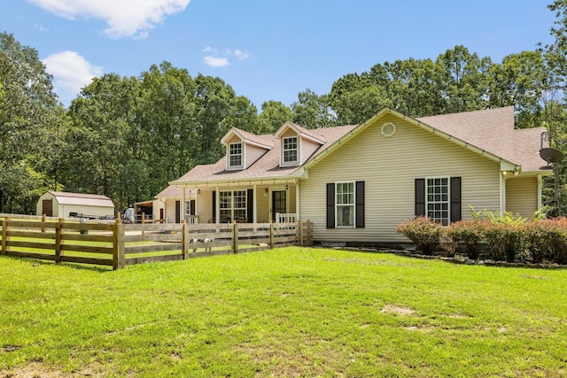 view of front of home with a front lawn and a shed