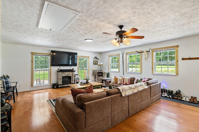 living room with a fireplace, light hardwood / wood-style floors, and ceiling fan