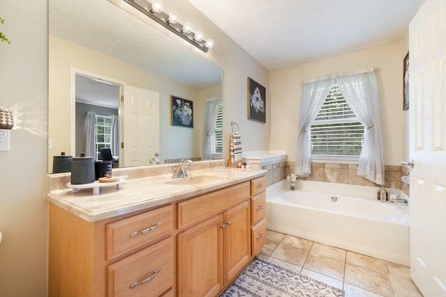 bathroom featuring vanity, a washtub, and tile patterned floors