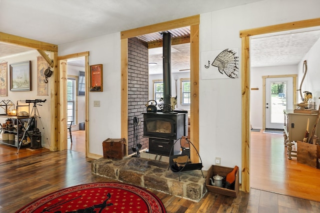 living room with a wood stove and dark wood-type flooring