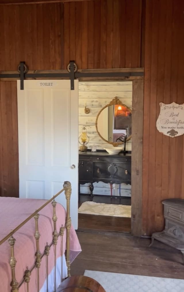 bedroom with wood walls and a barn door