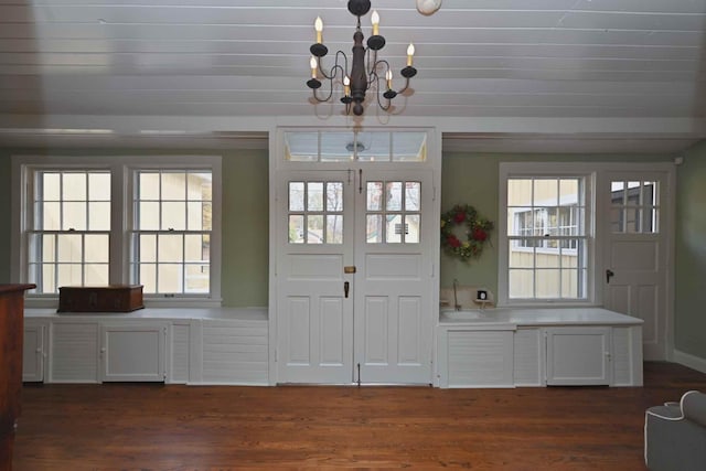 doorway featuring dark wood-type flooring, an inviting chandelier, and a healthy amount of sunlight