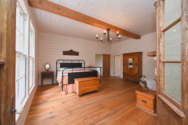 bedroom with a chandelier, light hardwood / wood-style flooring, beam ceiling, and wooden walls