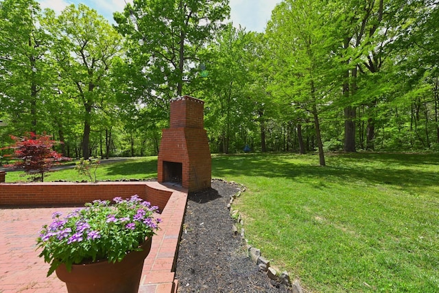 view of yard with an outdoor brick fireplace