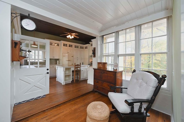 living area featuring wooden ceiling, a healthy amount of sunlight, dark hardwood / wood-style floors, and ceiling fan