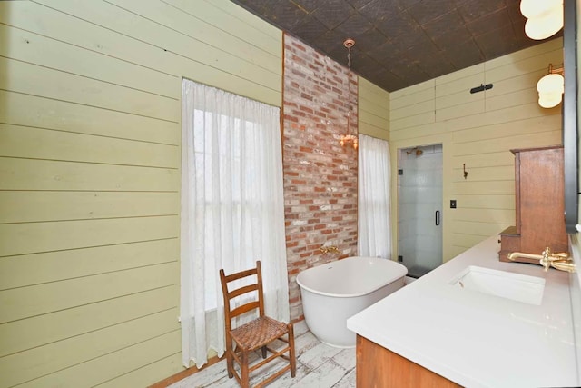 bathroom featuring wood-type flooring, vanity, wood walls, and shower with separate bathtub