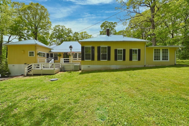 back of house featuring a lawn and a wooden deck