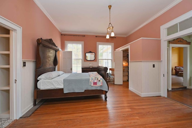 bedroom featuring ornamental molding and light wood-type flooring