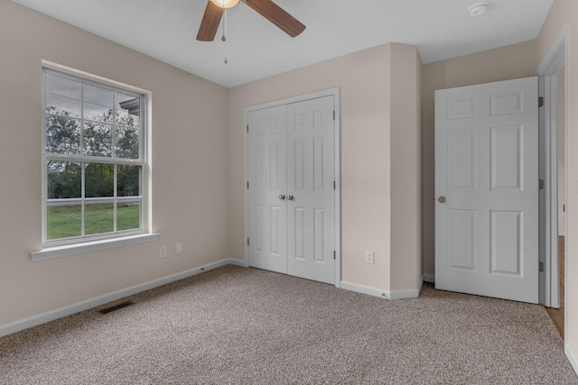 unfurnished bedroom featuring carpet floors, a closet, and ceiling fan