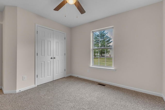 unfurnished bedroom with ceiling fan, a closet, and carpet flooring