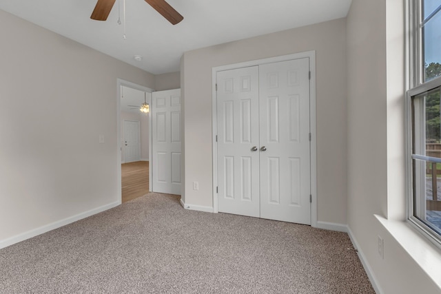 unfurnished bedroom featuring ceiling fan, carpet, and a closet