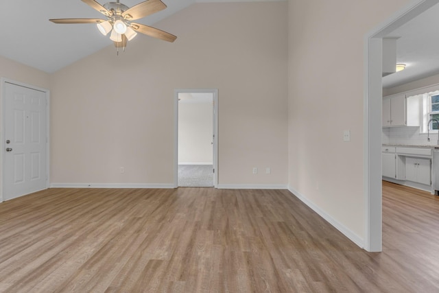 unfurnished room featuring ceiling fan, light hardwood / wood-style flooring, and lofted ceiling