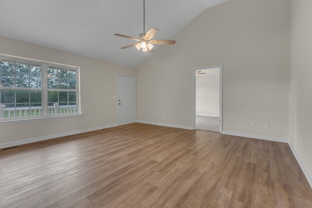 empty room with light wood-type flooring, high vaulted ceiling, and ceiling fan