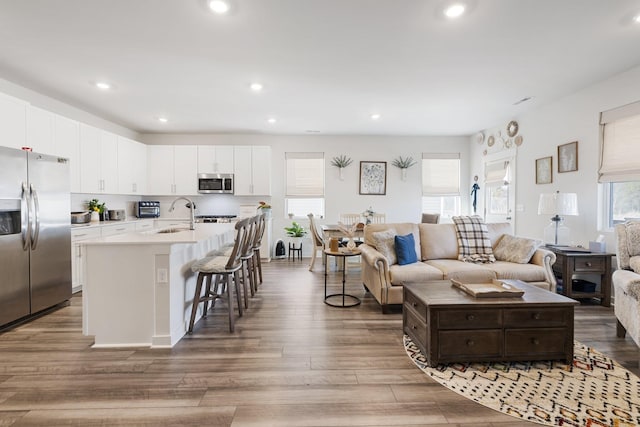 living room featuring sink and dark hardwood / wood-style flooring