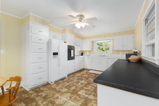 kitchen with crown molding, white fridge with ice dispenser, white cabinets, sink, and black oven