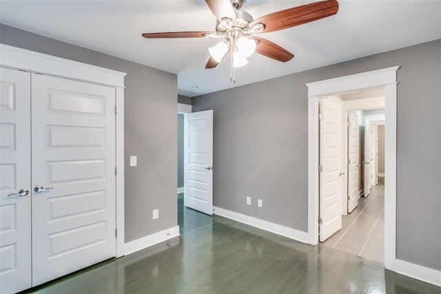 unfurnished bedroom featuring ceiling fan and a closet