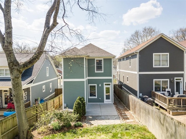 rear view of property featuring a wooden deck and a patio