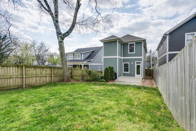 rear view of house with a patio area and a lawn