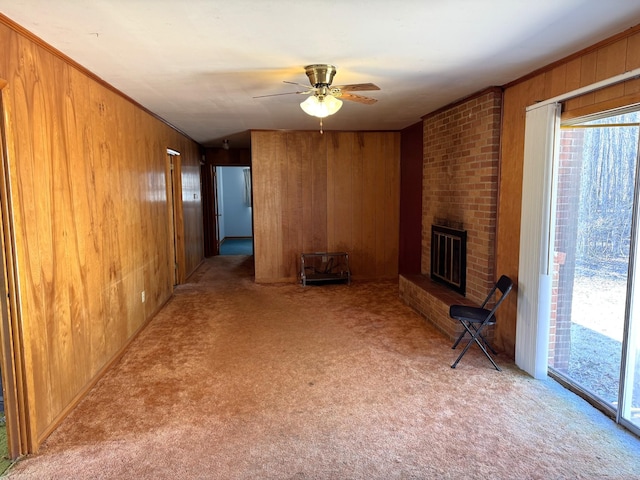 unfurnished living room featuring a brick fireplace, light colored carpet, and wooden walls