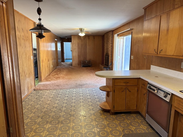 kitchen with dishwasher, kitchen peninsula, pendant lighting, ceiling fan, and wood walls