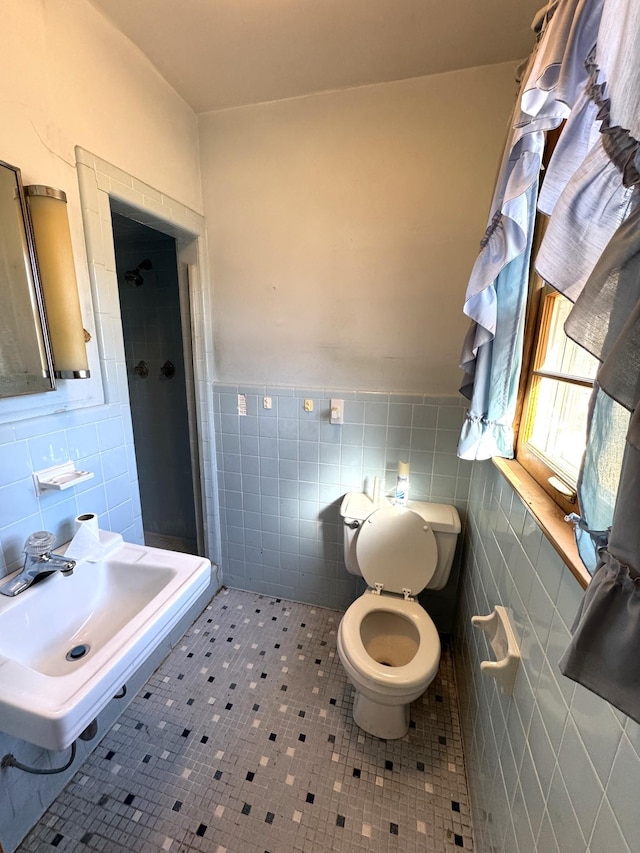 bathroom with toilet, an enclosed shower, tile walls, sink, and tile patterned floors