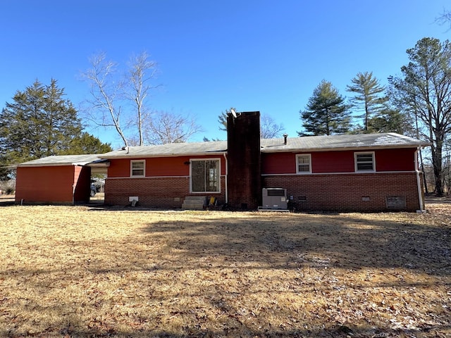 rear view of property featuring central AC unit and a carport