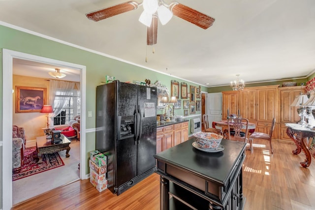 kitchen featuring light hardwood / wood-style floors, crown molding, and black fridge with ice dispenser