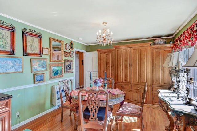 dining space featuring an inviting chandelier, heating unit, crown molding, and light wood-type flooring