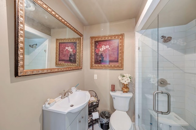 bathroom featuring toilet, a shower with shower door, and vanity