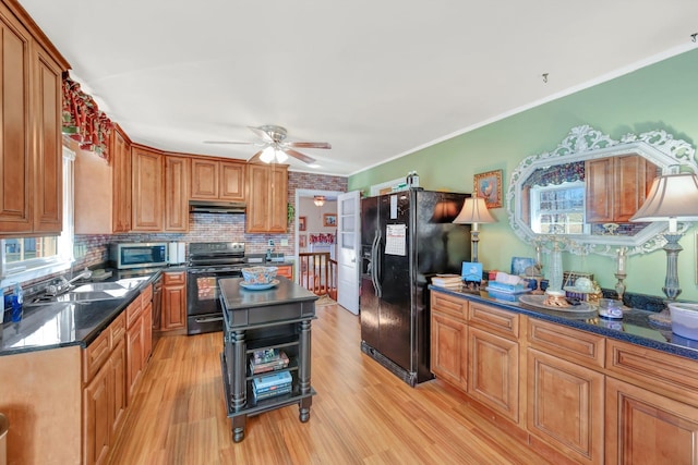 kitchen with black appliances, a kitchen island, light hardwood / wood-style flooring, and sink