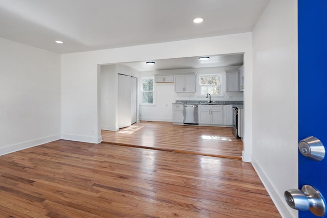 unfurnished living room with sink and hardwood / wood-style floors