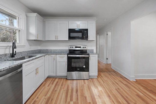 kitchen featuring sink, light stone countertops, white cabinets, and appliances with stainless steel finishes