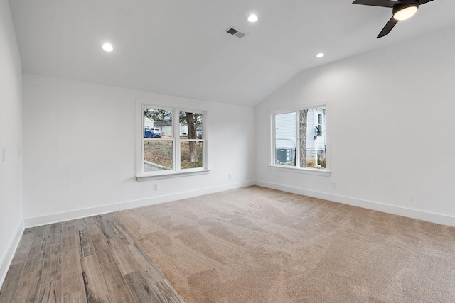 carpeted spare room featuring lofted ceiling and ceiling fan