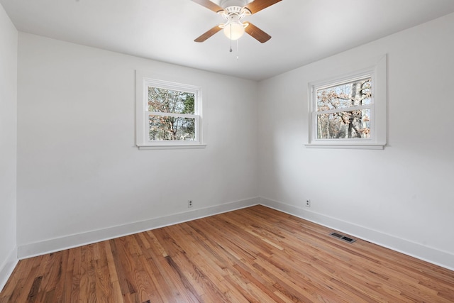 spare room with ceiling fan, a healthy amount of sunlight, and light wood-type flooring