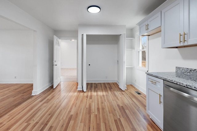 kitchen with dishwasher, light stone countertops, and light hardwood / wood-style flooring