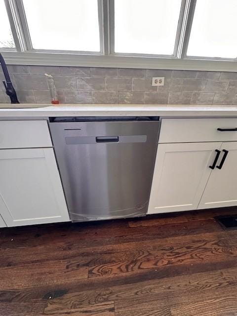 kitchen with stainless steel dishwasher, decorative backsplash, white cabinets, and dark hardwood / wood-style flooring