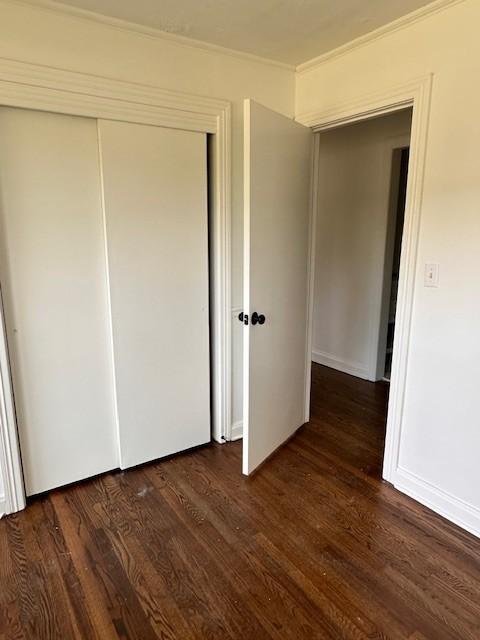 unfurnished bedroom featuring a closet and dark hardwood / wood-style floors