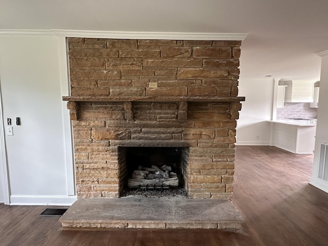 details with hardwood / wood-style flooring, a stone fireplace, crown molding, and tasteful backsplash