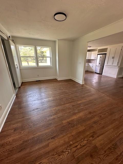 unfurnished room featuring dark hardwood / wood-style floors and a barn door