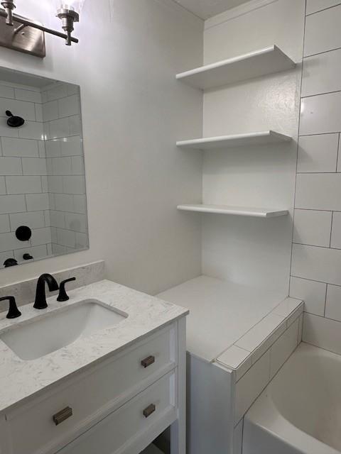 bathroom with vanity and tiled shower / bath