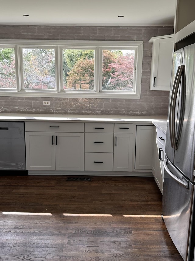 kitchen featuring white cabinetry, appliances with stainless steel finishes, dark wood-type flooring, and tasteful backsplash