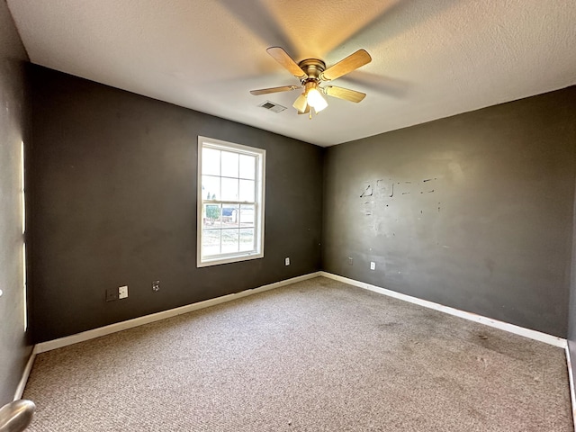 carpeted empty room with ceiling fan and a textured ceiling