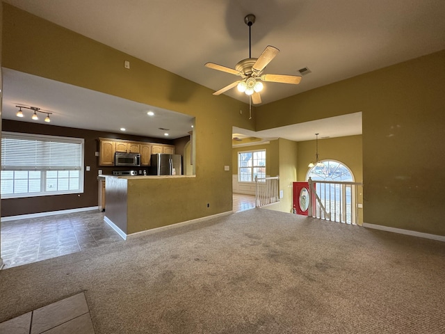 unfurnished living room featuring ceiling fan and carpet