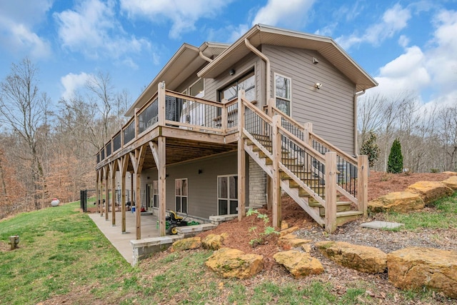 back of house with a patio area, a lawn, and a deck