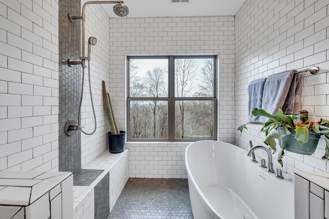 bathroom with tile walls, tile patterned floors, and plus walk in shower