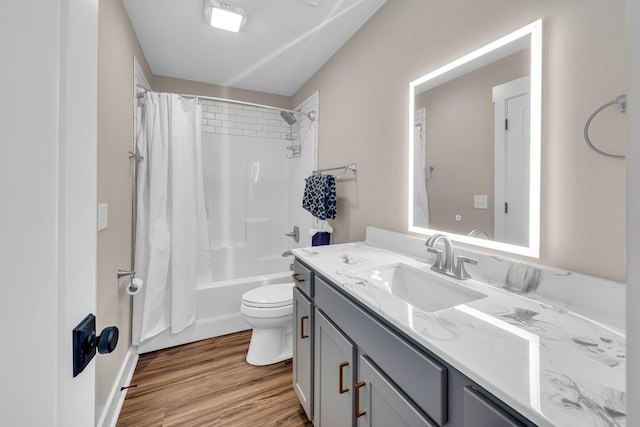 full bathroom with shower / bath combo with shower curtain, hardwood / wood-style floors, toilet, and vanity