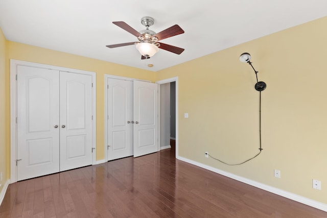 unfurnished bedroom with ceiling fan and dark hardwood / wood-style flooring