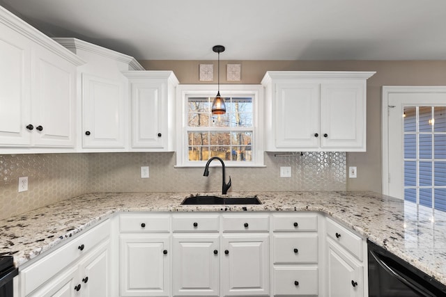 kitchen featuring pendant lighting, dishwasher, sink, backsplash, and white cabinets